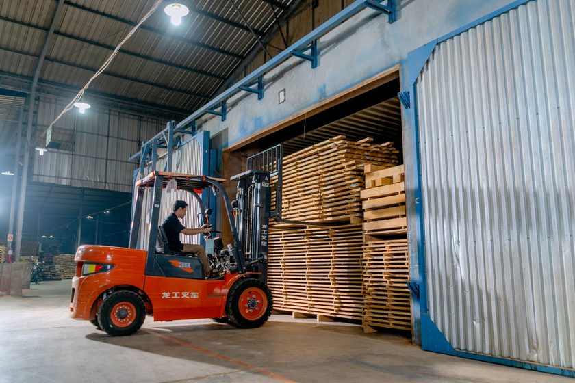 Forklift moving timber in a yard